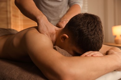 Massage therapist working with patient in clinic, closeup