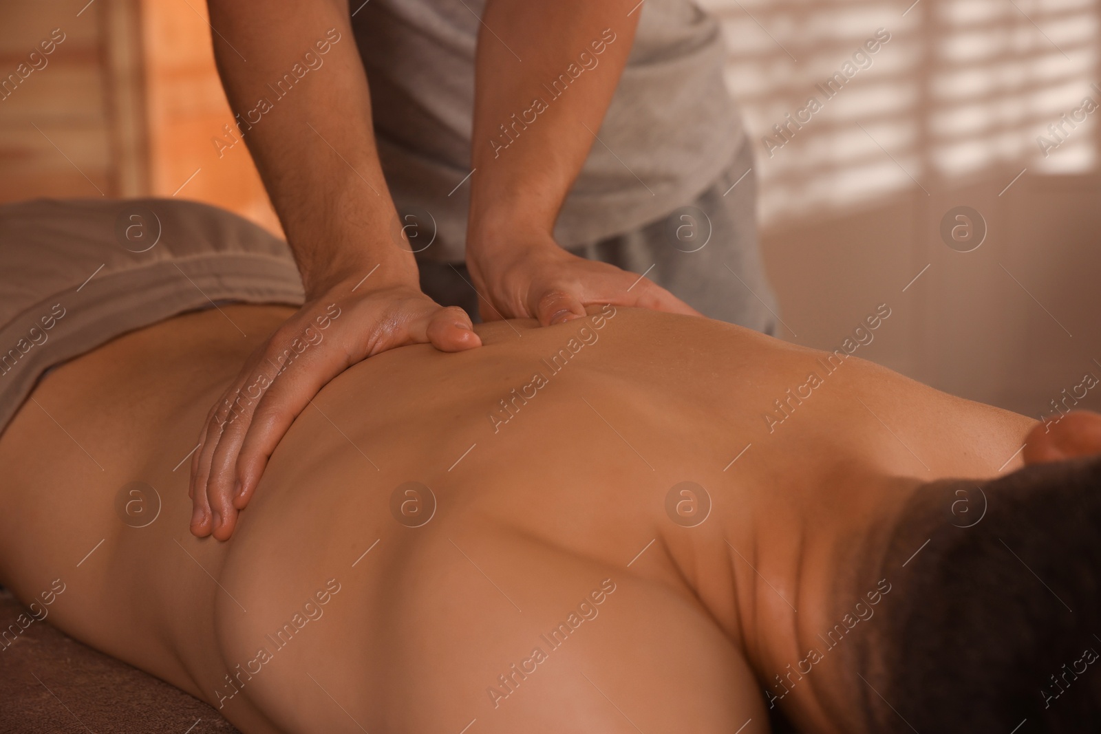 Photo of Massage therapist working with patient in clinic, closeup