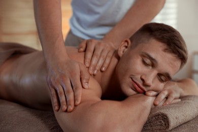 Massage therapist working with patient in clinic, closeup