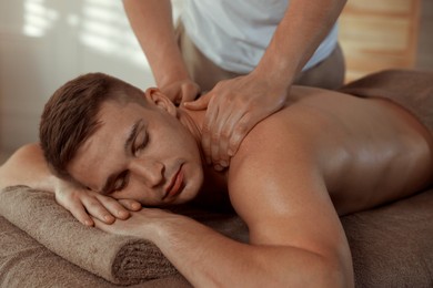 Massage therapist working with patient in clinic, closeup