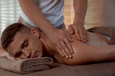 Massage therapist working with patient in clinic, closeup