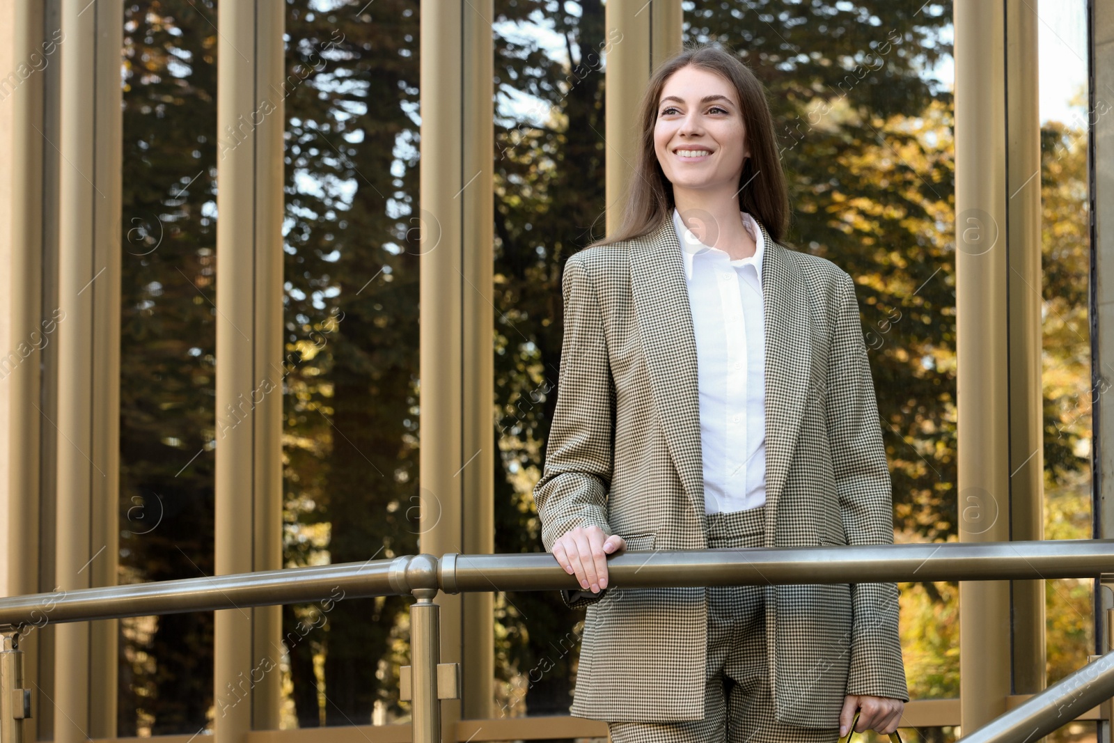 Photo of Portrait of young woman wearing stylish suit outdoors