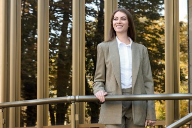 Photo of Portrait of young woman wearing stylish suit outdoors