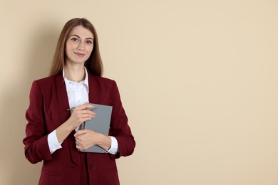 Photo of Portrait of smiling banker with book on beige background. Space for text