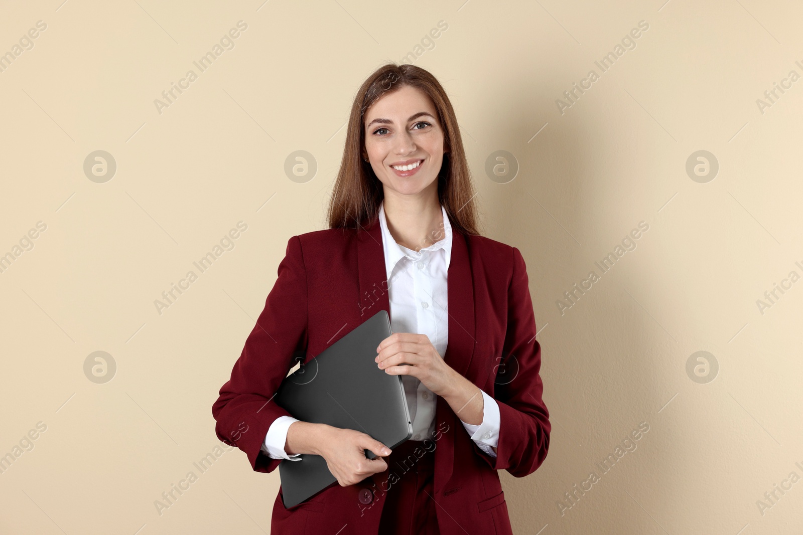 Photo of Portrait of smiling banker with laptop on beige background