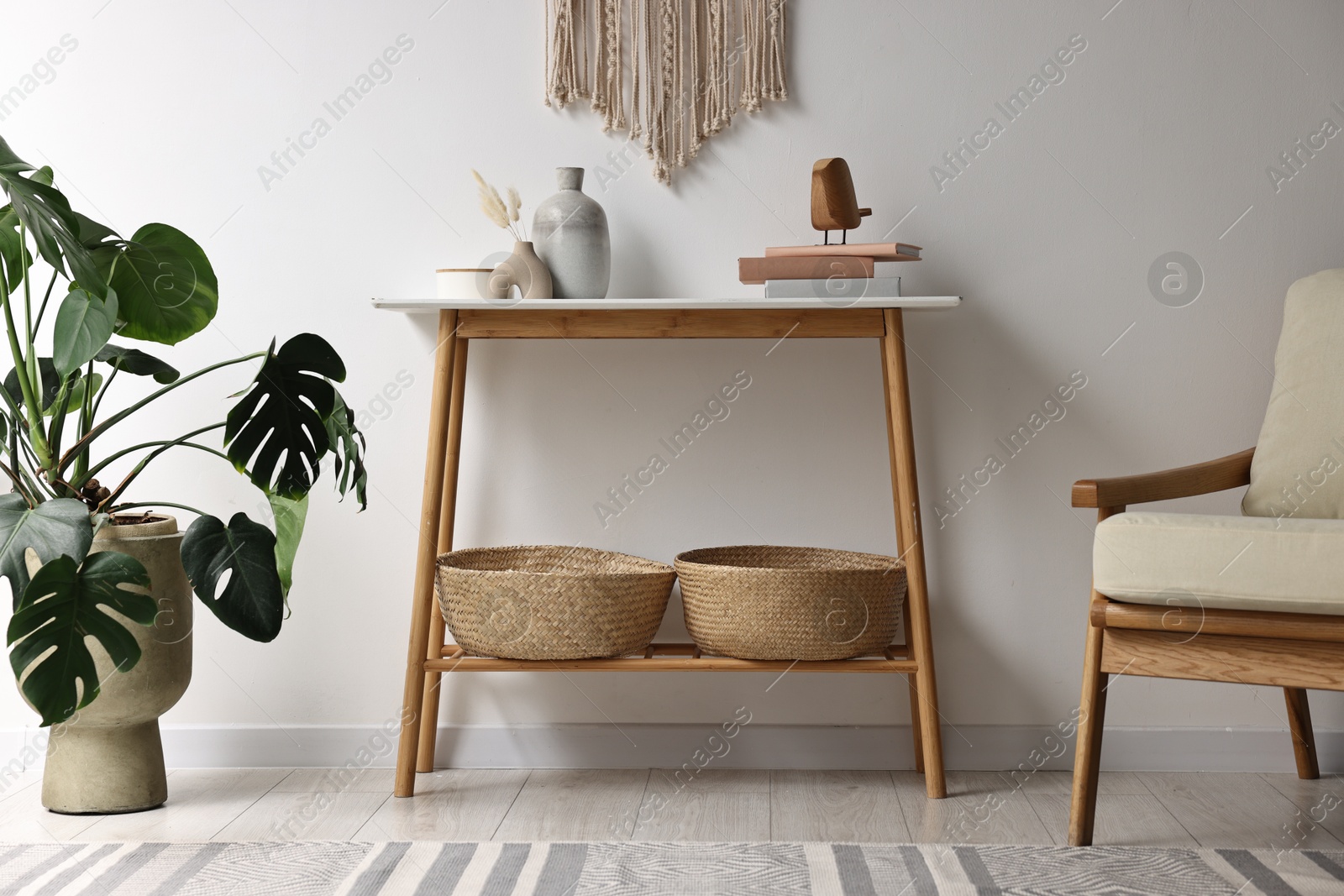 Photo of Stylish room interior with console table near white wall