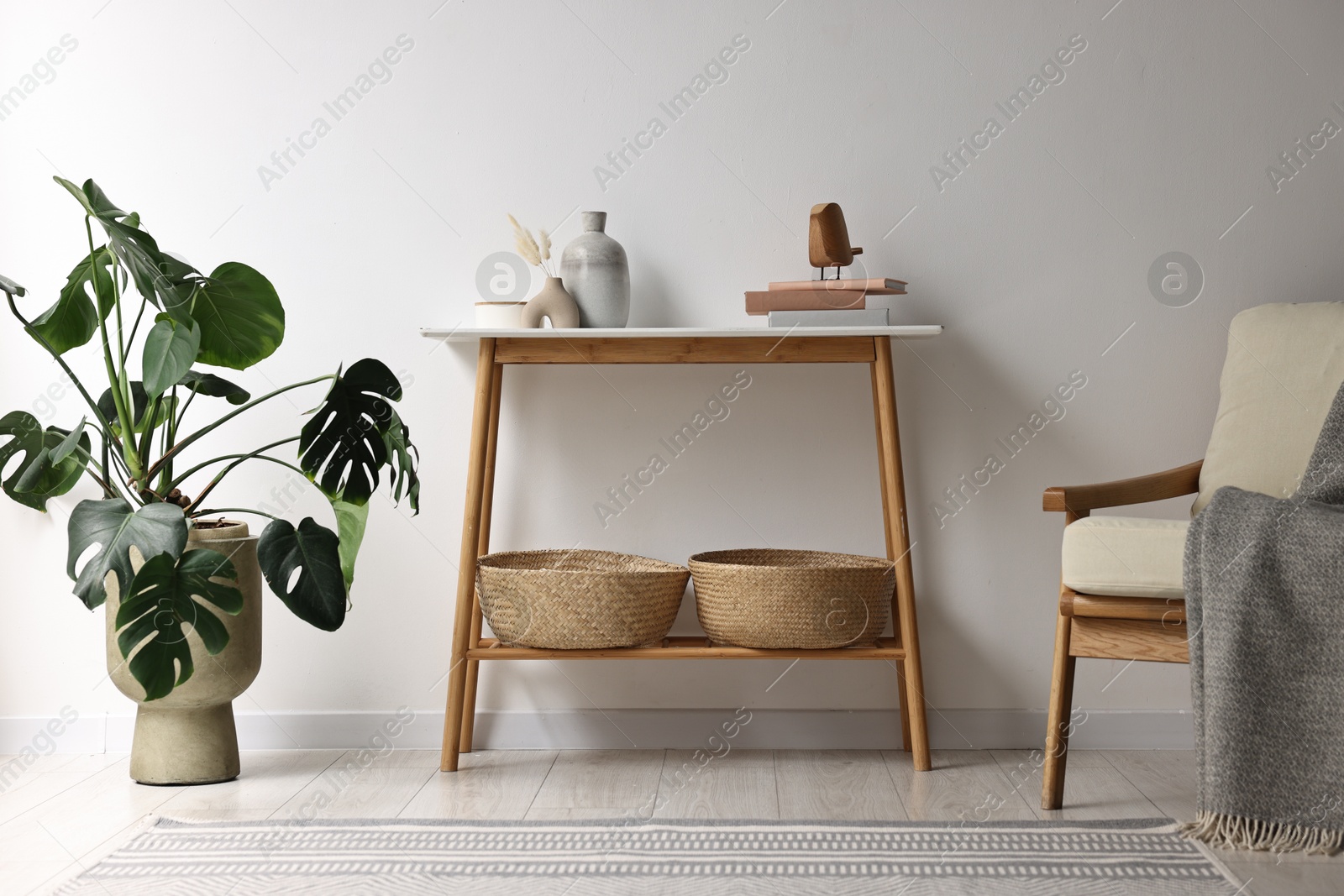 Photo of Stylish room interior with console table near white wall