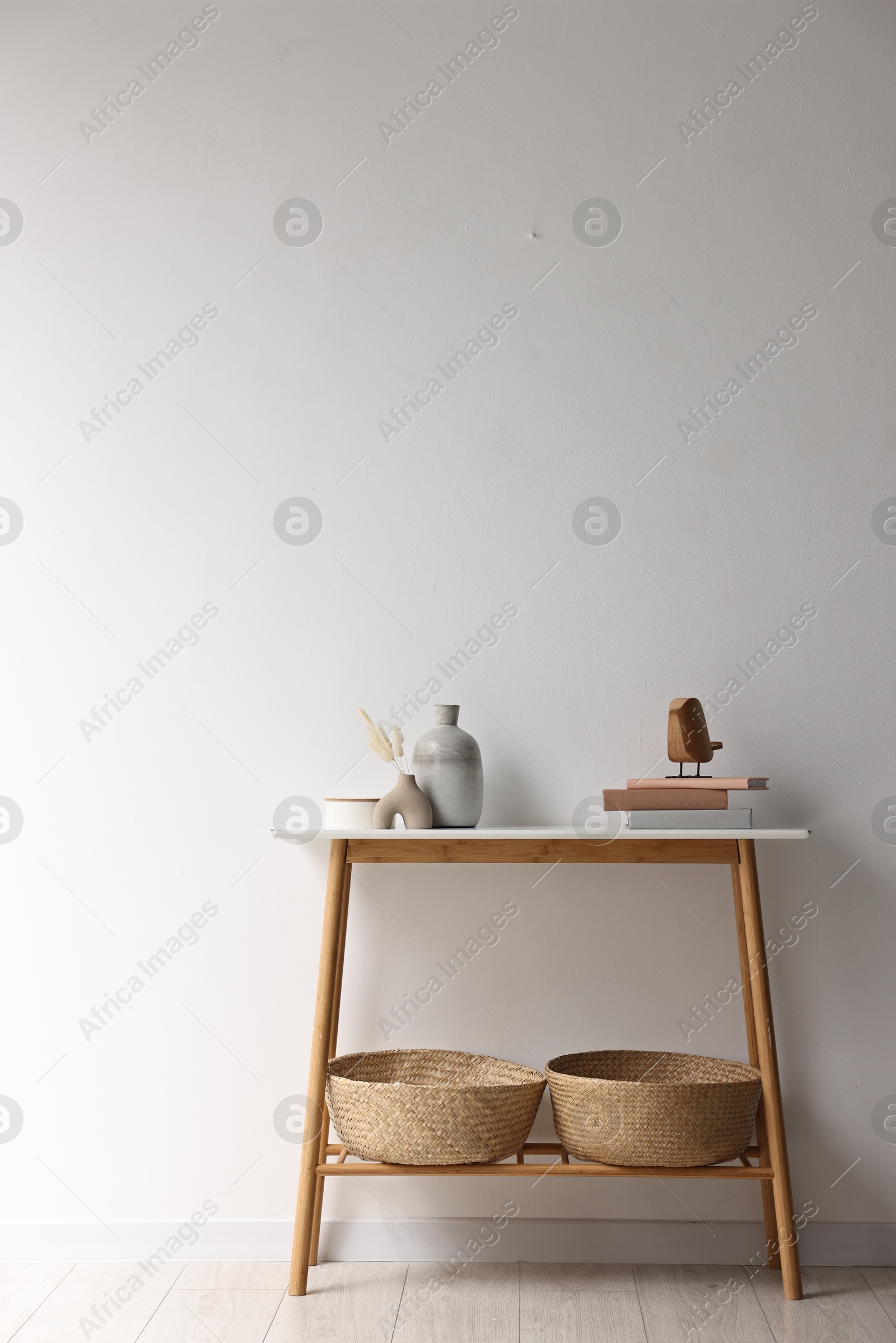 Photo of Stylish console table with decor near white wall indoors