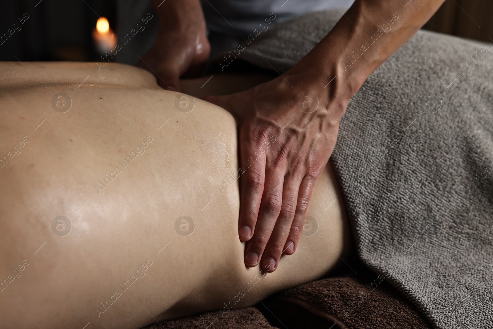 Photo of Professional physiotherapist doing back massage for his client indoors, closeup