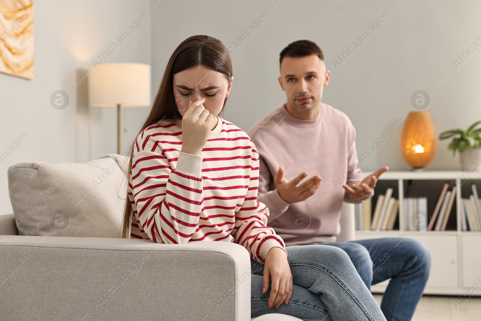 Photo of Upset woman ignoring her husband at home. Relationship problems