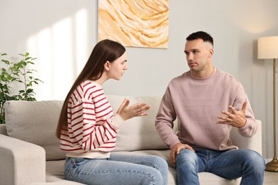 Young couple arguing on sofa at home