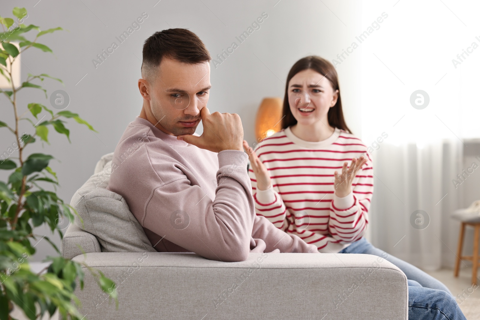 Photo of Husband ignoring his emotional wife at home