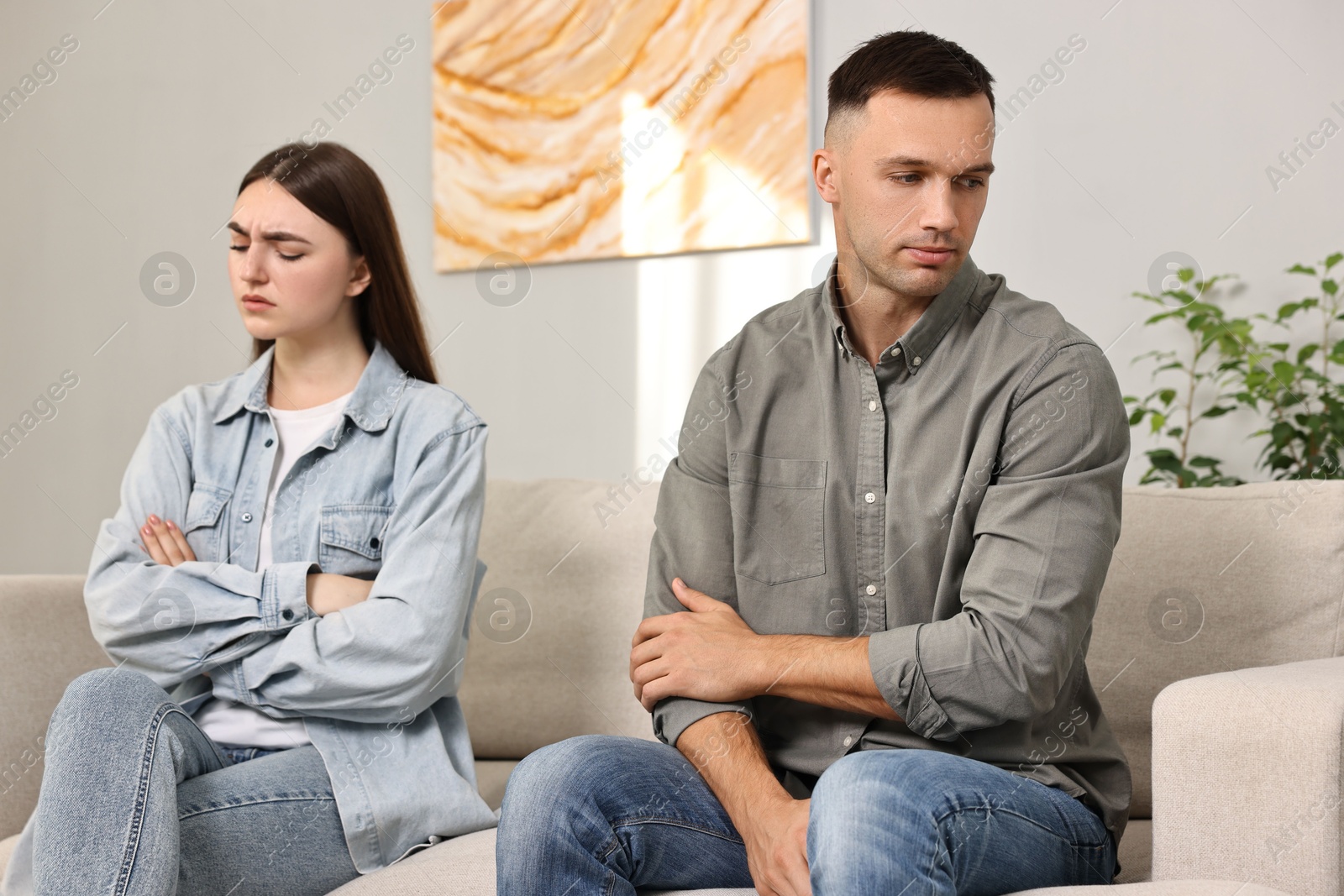 Photo of Offended couple ignoring each other at home