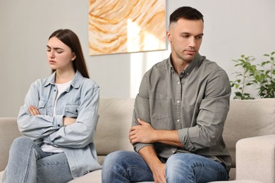 Photo of Offended couple ignoring each other at home