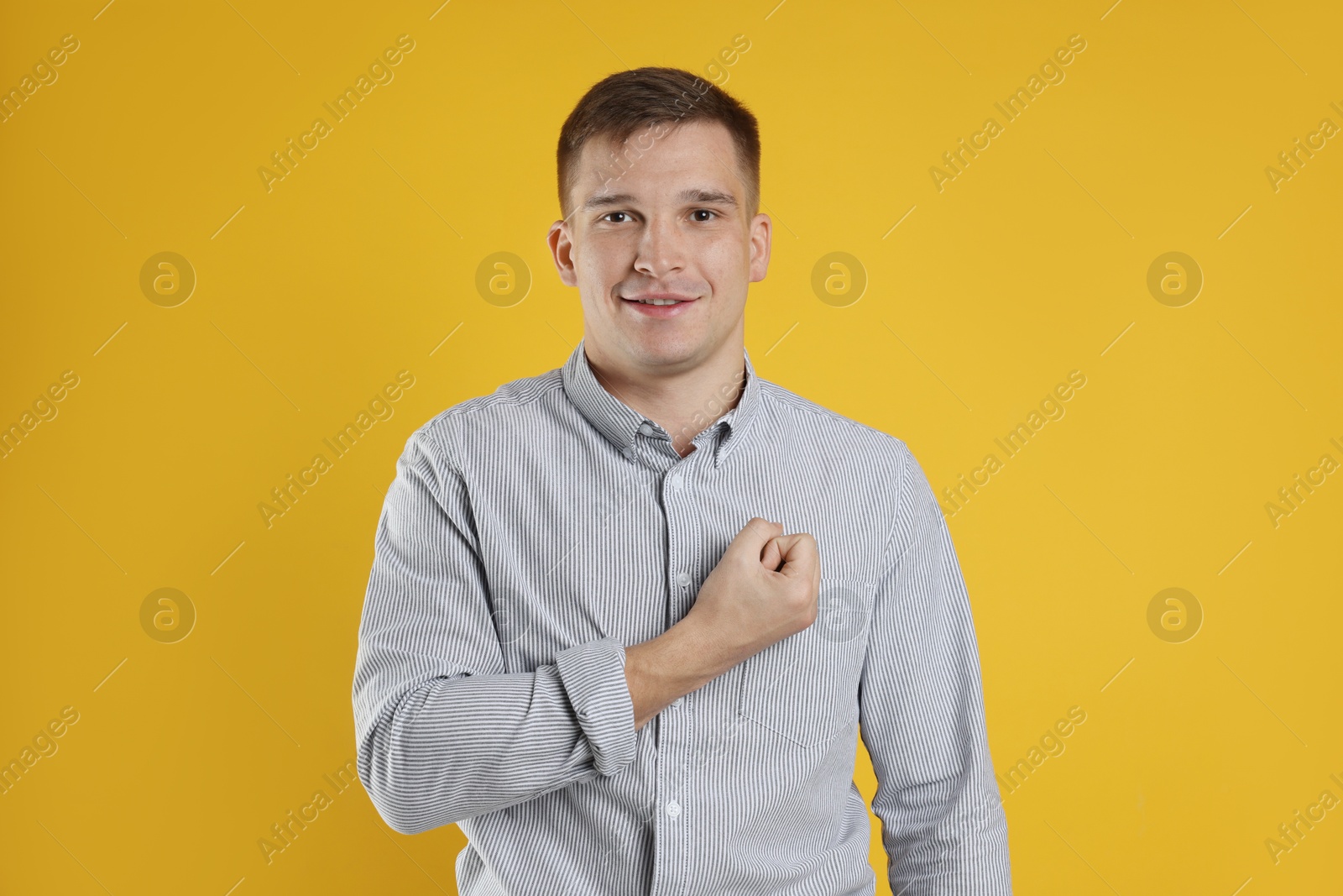 Photo of Man making promise on orange background. Oath gesture