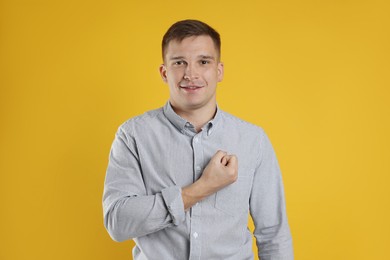 Photo of Man making promise on orange background. Oath gesture