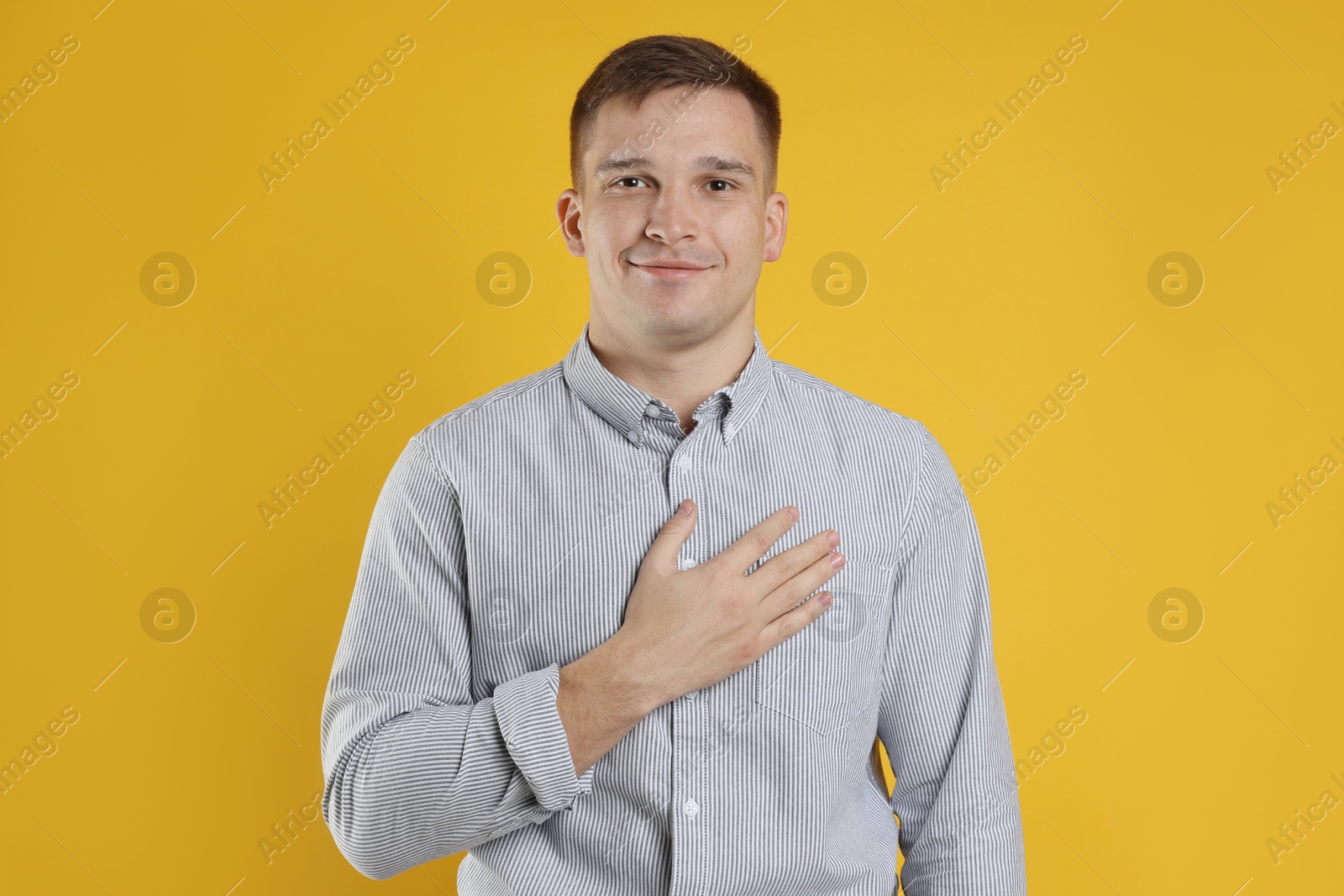 Photo of Man making promise on orange background. Oath gesture