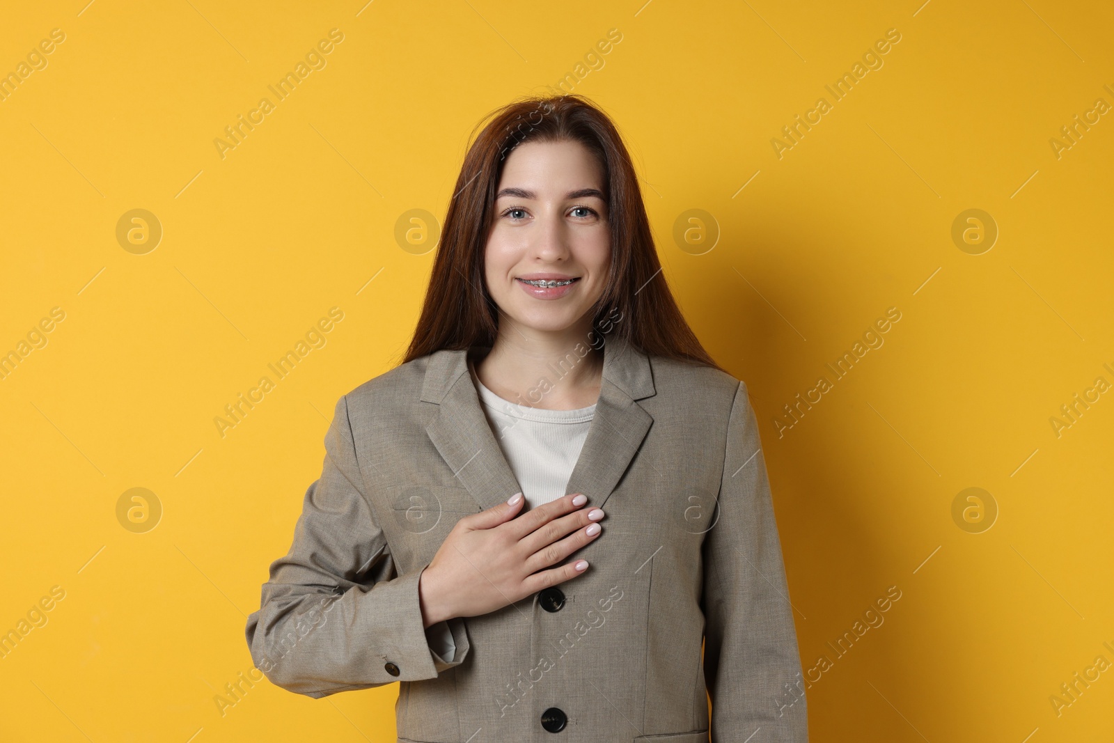 Photo of Woman making promise on orange background. Oath gesture