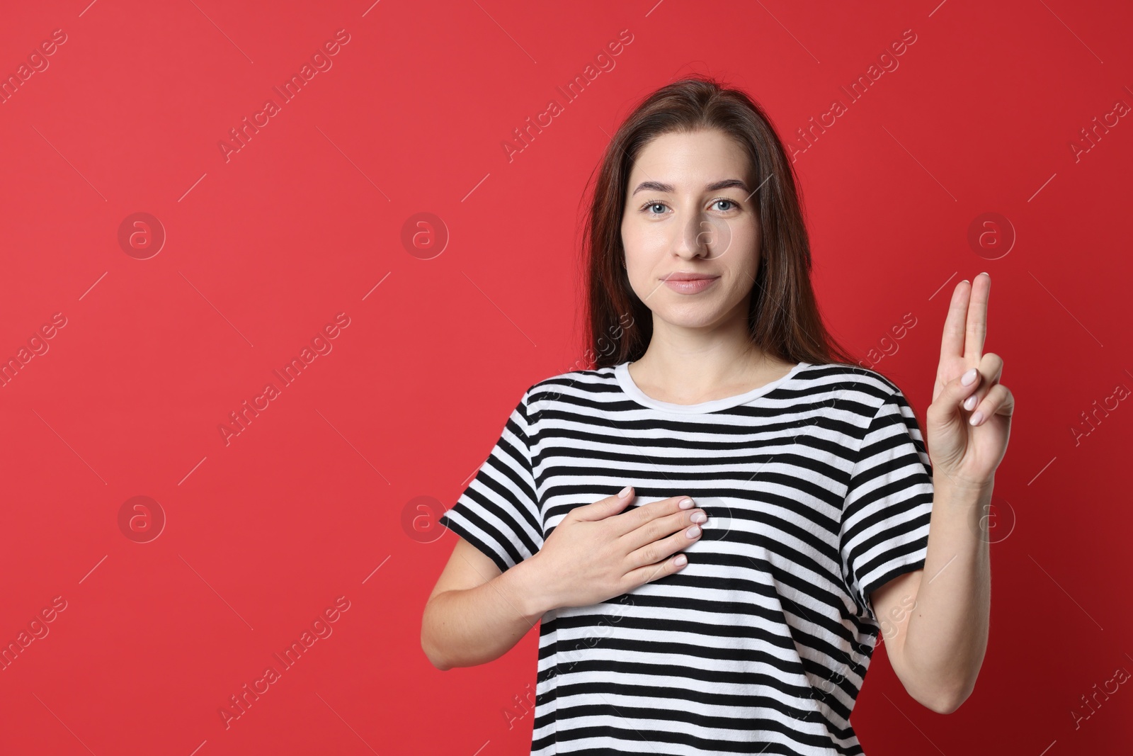 Photo of Woman showing oath gesture on red background, space for text. Making promise