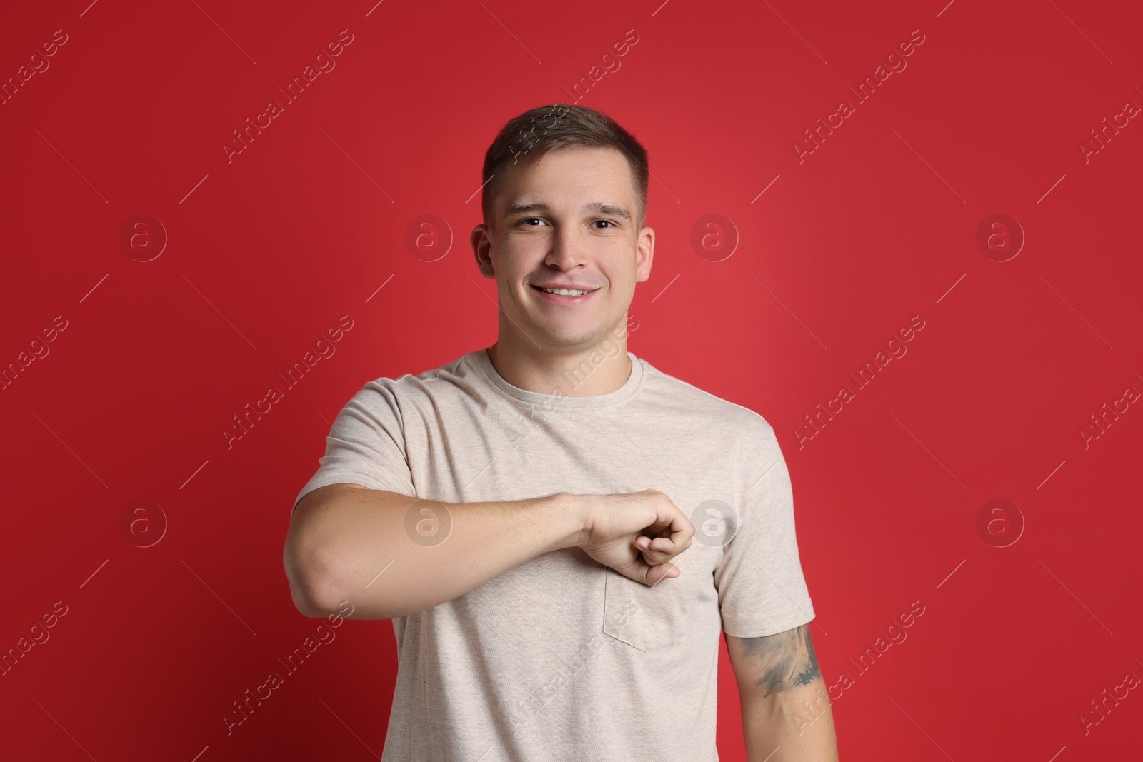 Photo of Man making promise on red background. Oath gesture