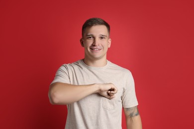 Photo of Man making promise on red background. Oath gesture