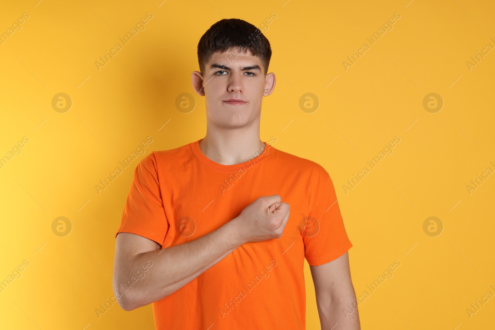 Photo of Man showing oath gesture on orange background