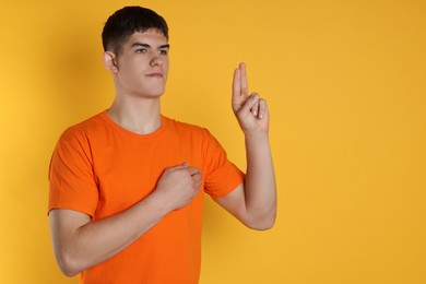 Photo of Man showing oath gesture on orange background