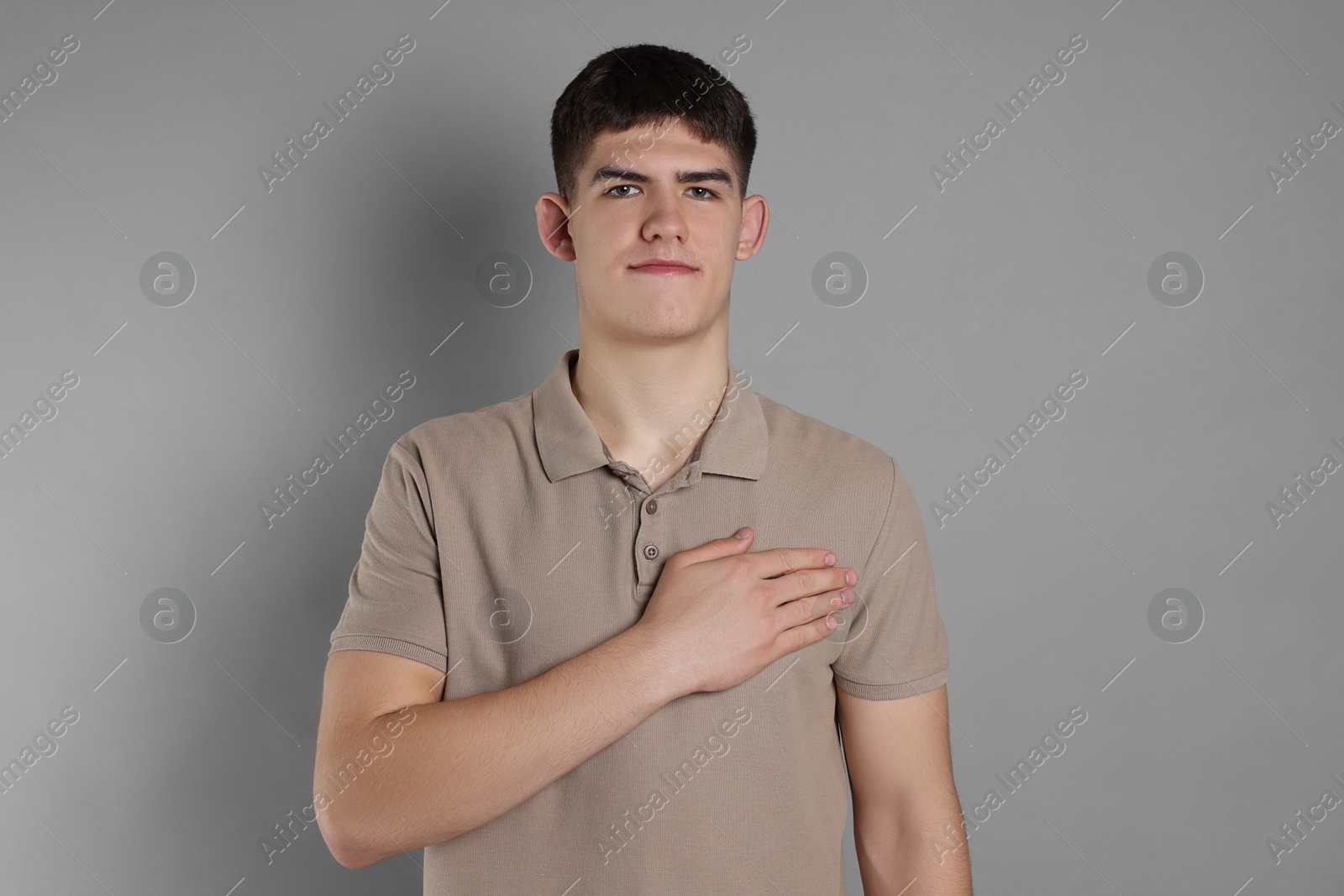 Photo of Man showing oath gesture on grey background