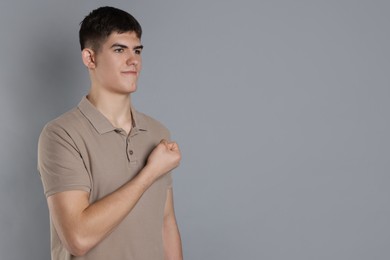 Man showing oath gesture on grey background. Space for text