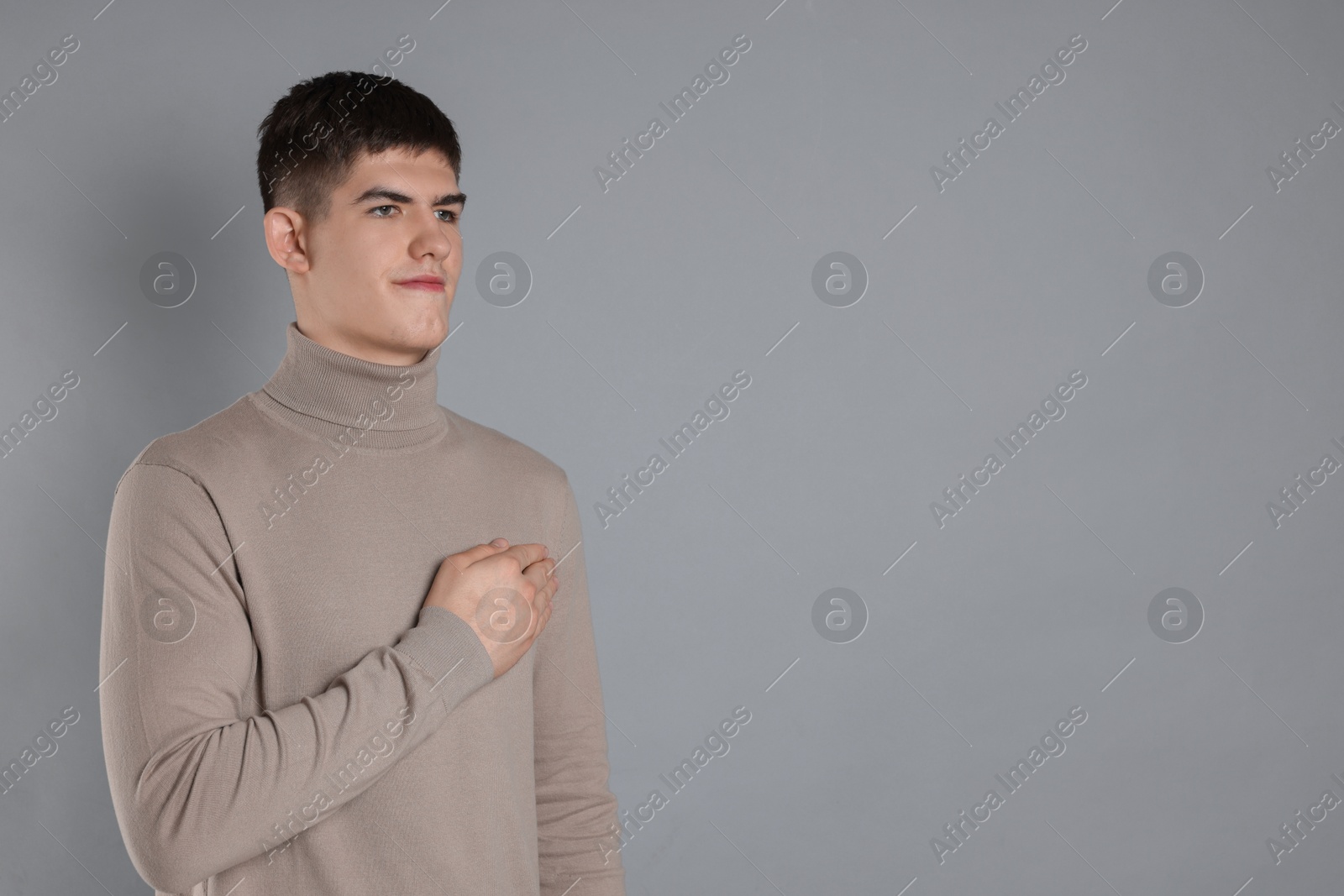 Photo of Man showing oath gesture on grey background. Space for text