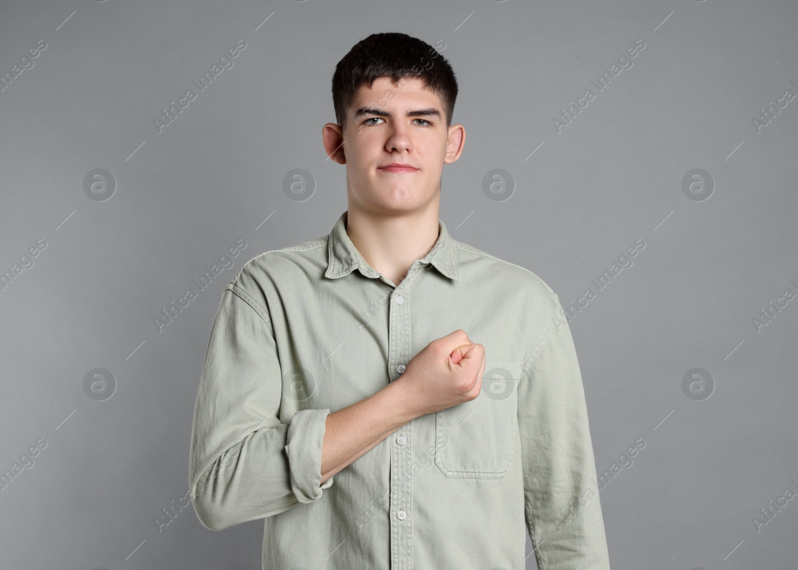 Photo of Man showing oath gesture on grey background