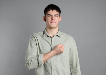 Man showing oath gesture on grey background