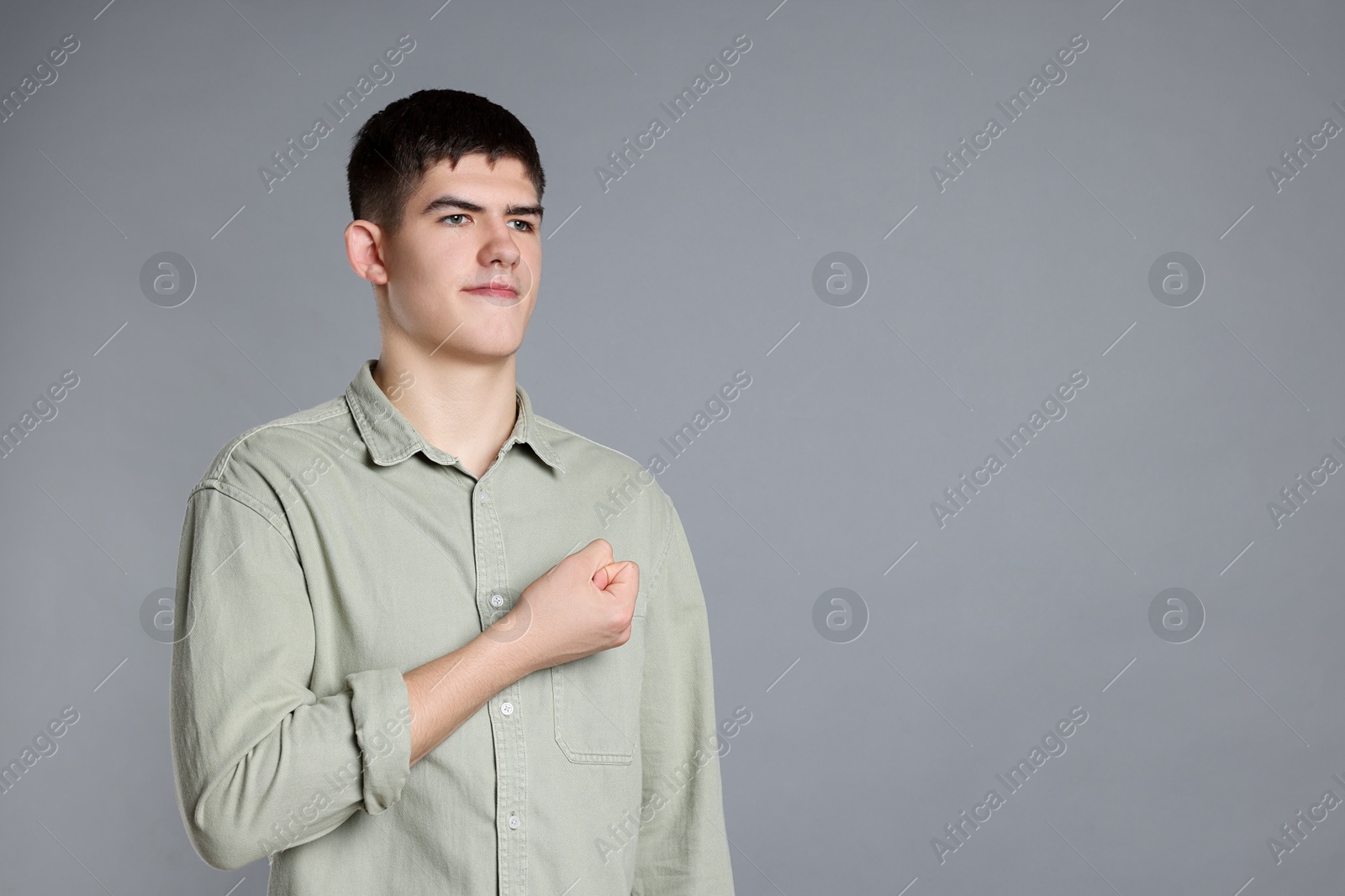 Photo of Man showing oath gesture on grey background. Space for text