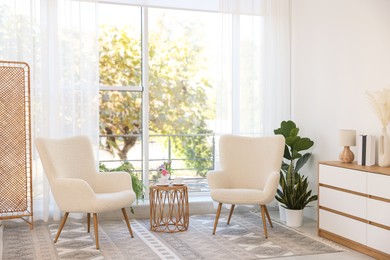 Stylish living room interior with soft white armchairs