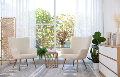 Stylish living room interior with soft white armchairs