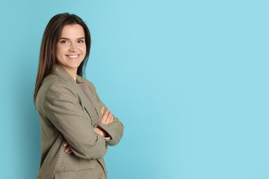 Portrait of banker with crossed arms on light blue background, space for text