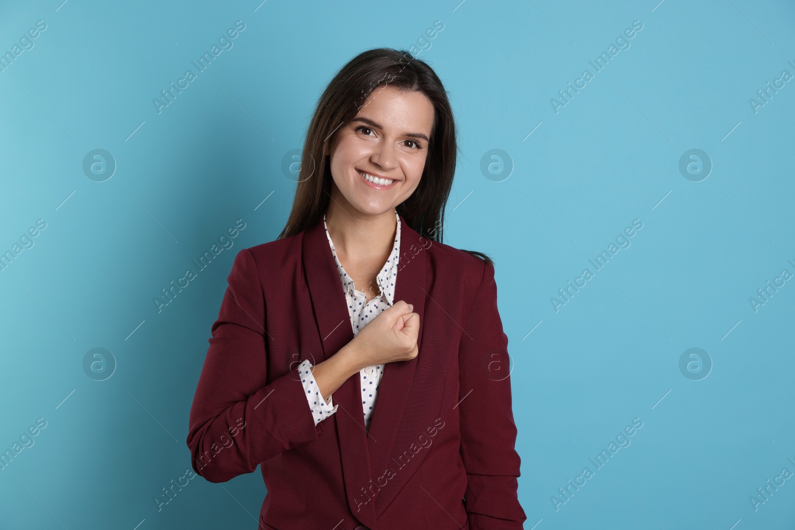 Photo of Woman making promise on light blue background. Oath gesture