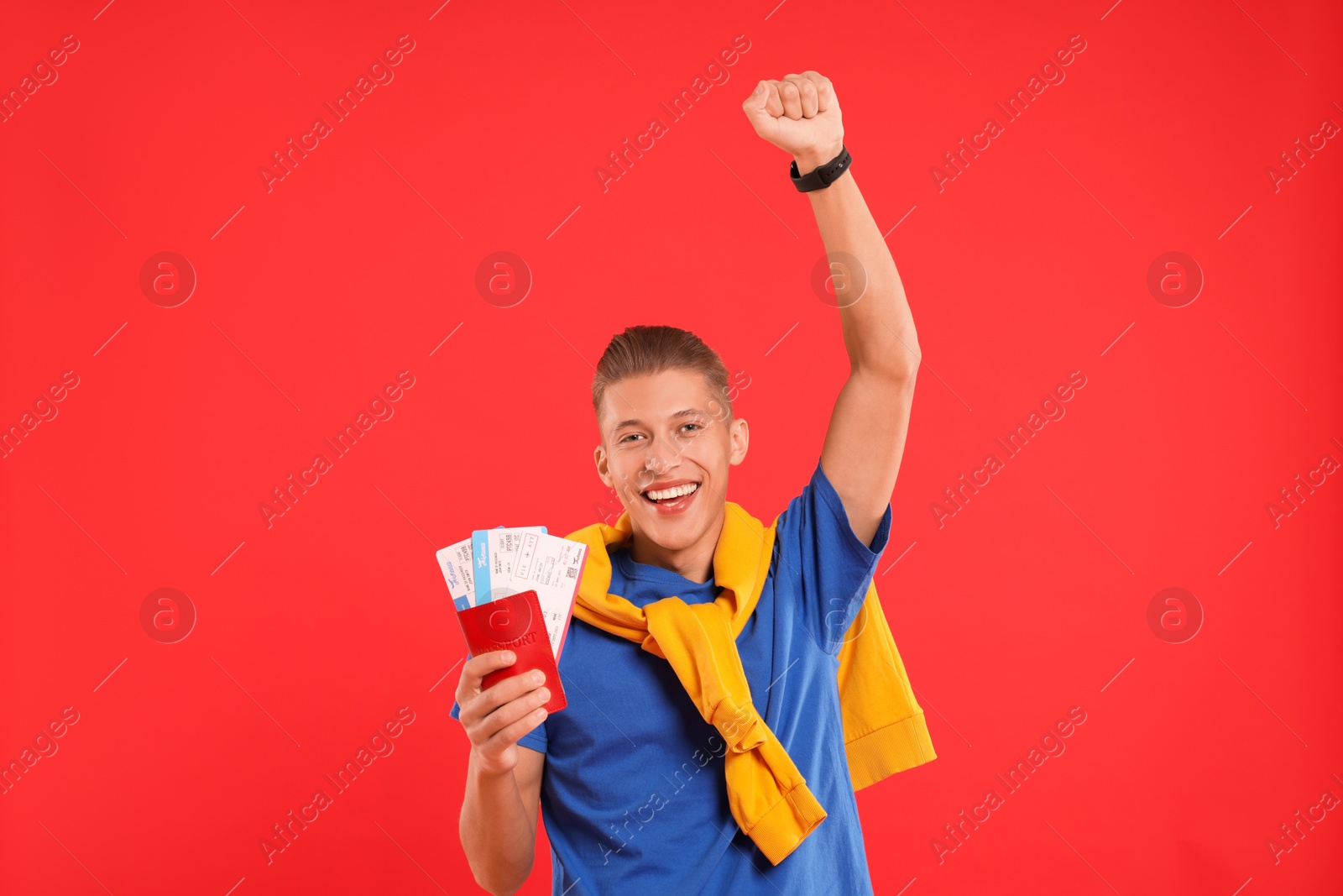 Photo of Happy traveller with passport and tickets on red background