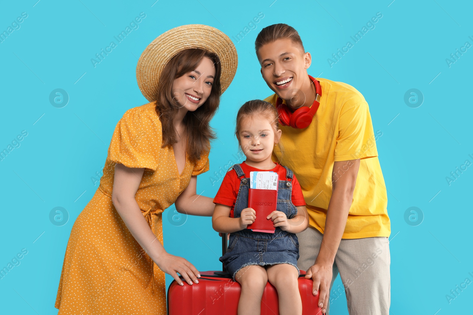 Photo of Travellers with suitcase, passport and tickets. Happy family on light blue background