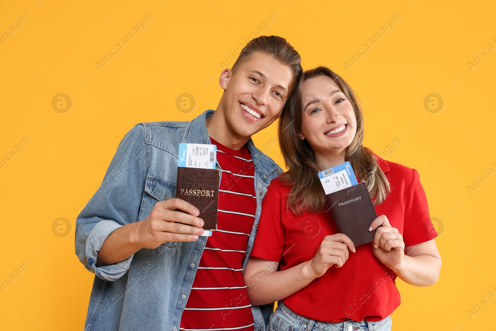 Photo of Happy travellers with passports and tickets on yellow background