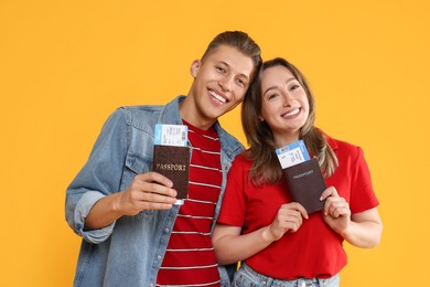 Photo of Happy travellers with passports and tickets on yellow background