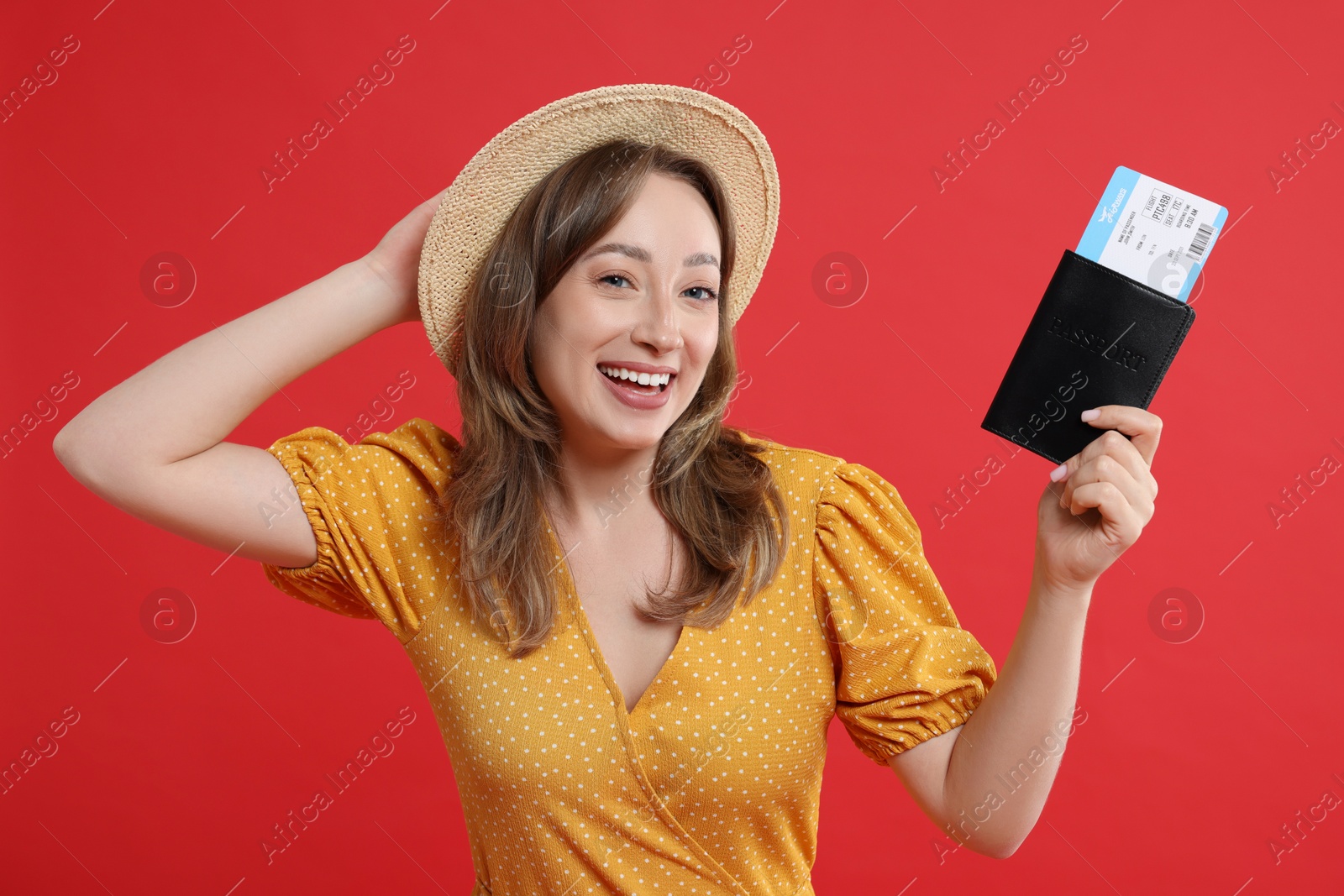 Photo of Happy traveller with passport and ticket on red background