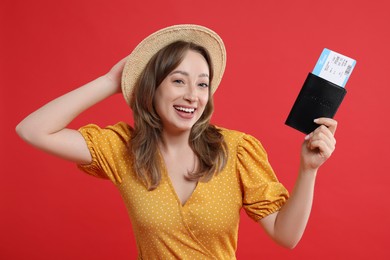 Photo of Happy traveller with passport and ticket on red background