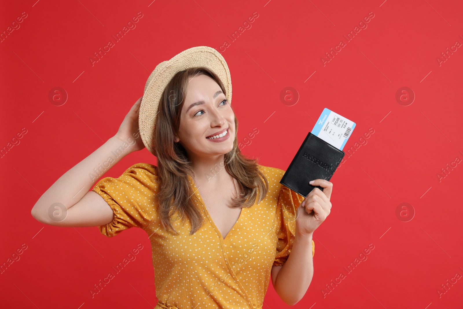 Photo of Happy traveller with passport and ticket on red background