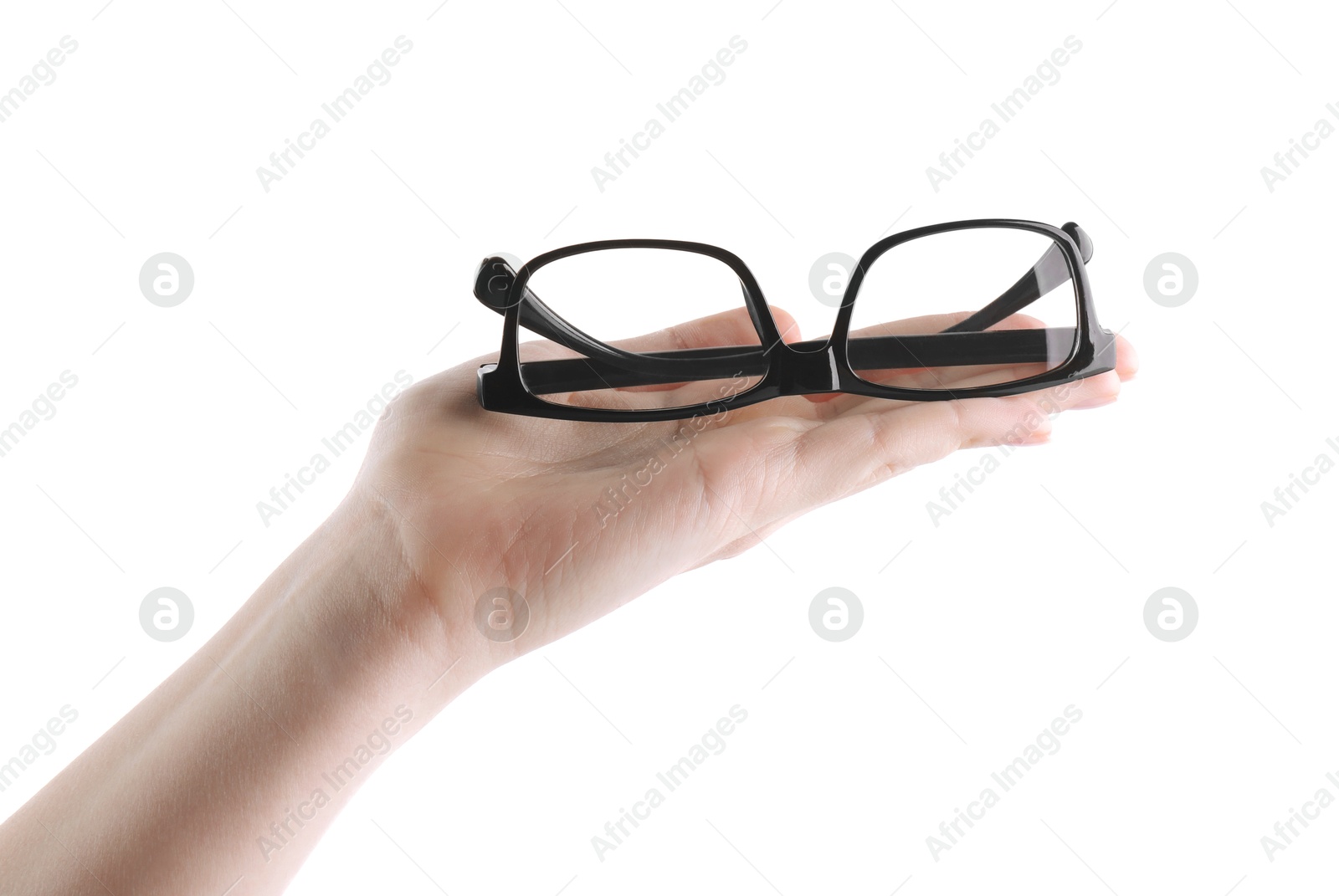 Photo of Woman holding glasses with black plastic frame on white background, closeup