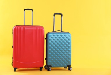 Photo of Travel abroad. Packed suitcases on yellow background, space for text