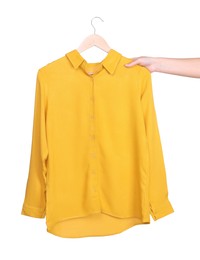 Photo of Woman holding hanger with yellow shirt on white background, closeup