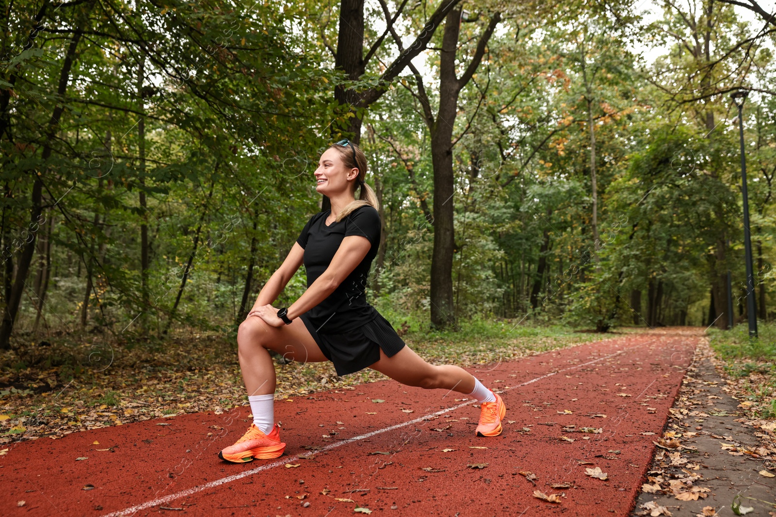 Photo of Young athletic woman stretching in park. Healthy lifestyle