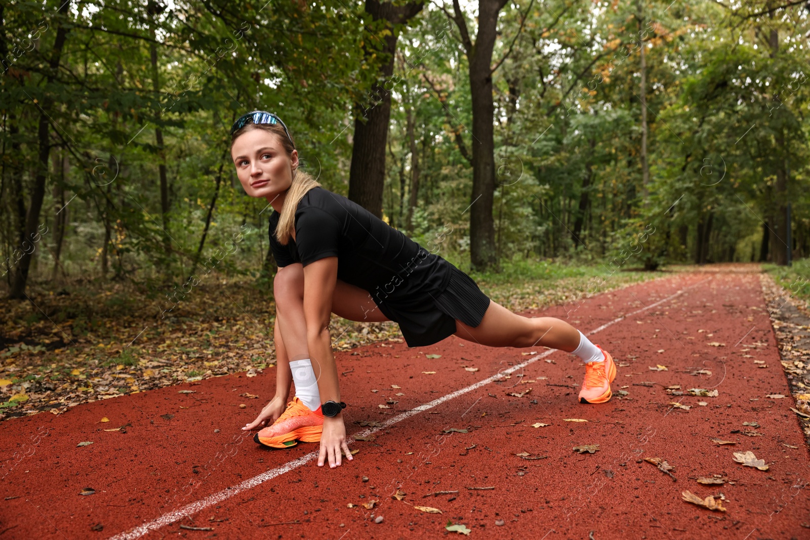 Photo of Young athletic woman stretching in park, space for text