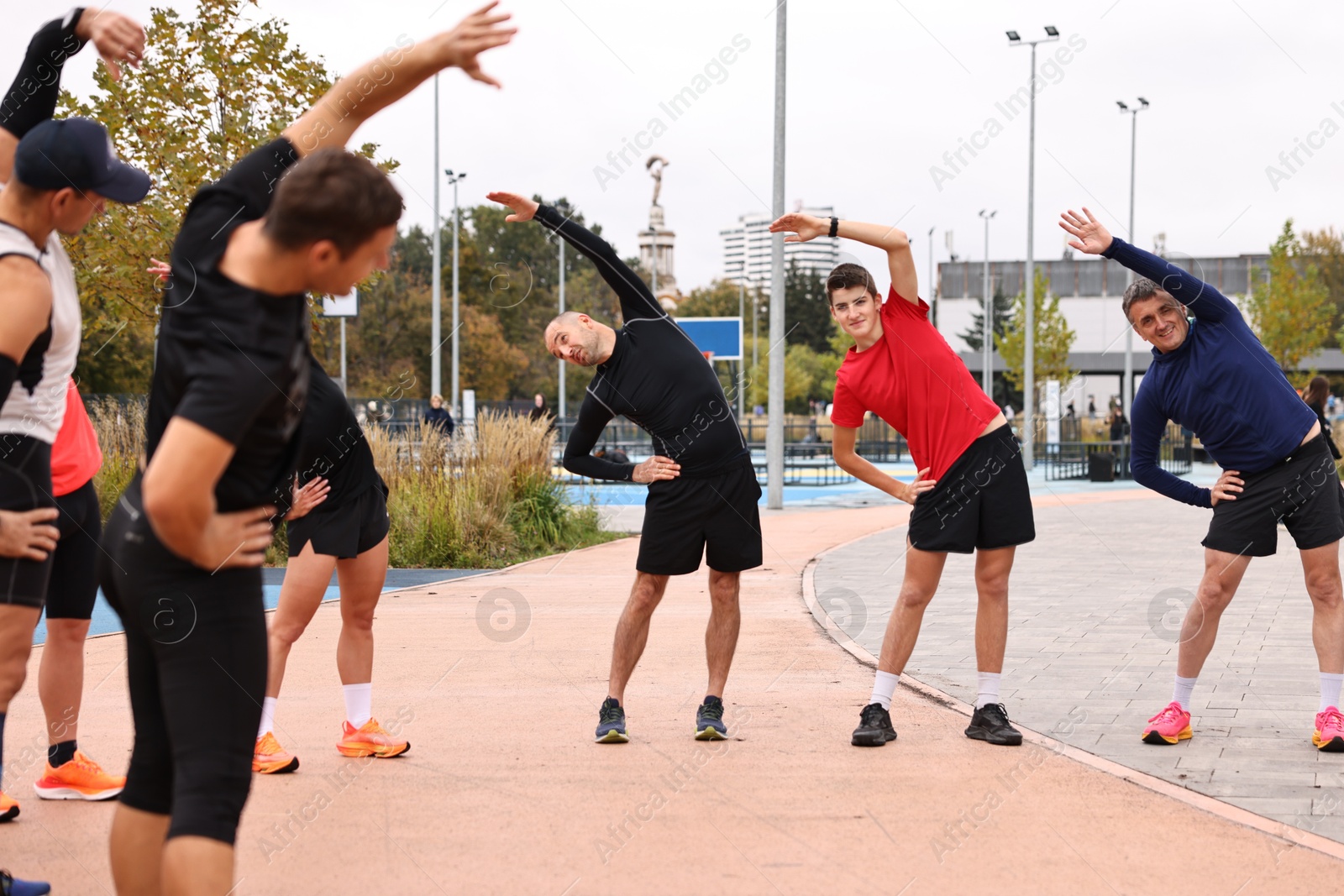 Photo of Group of people exercising and stretching outdoors